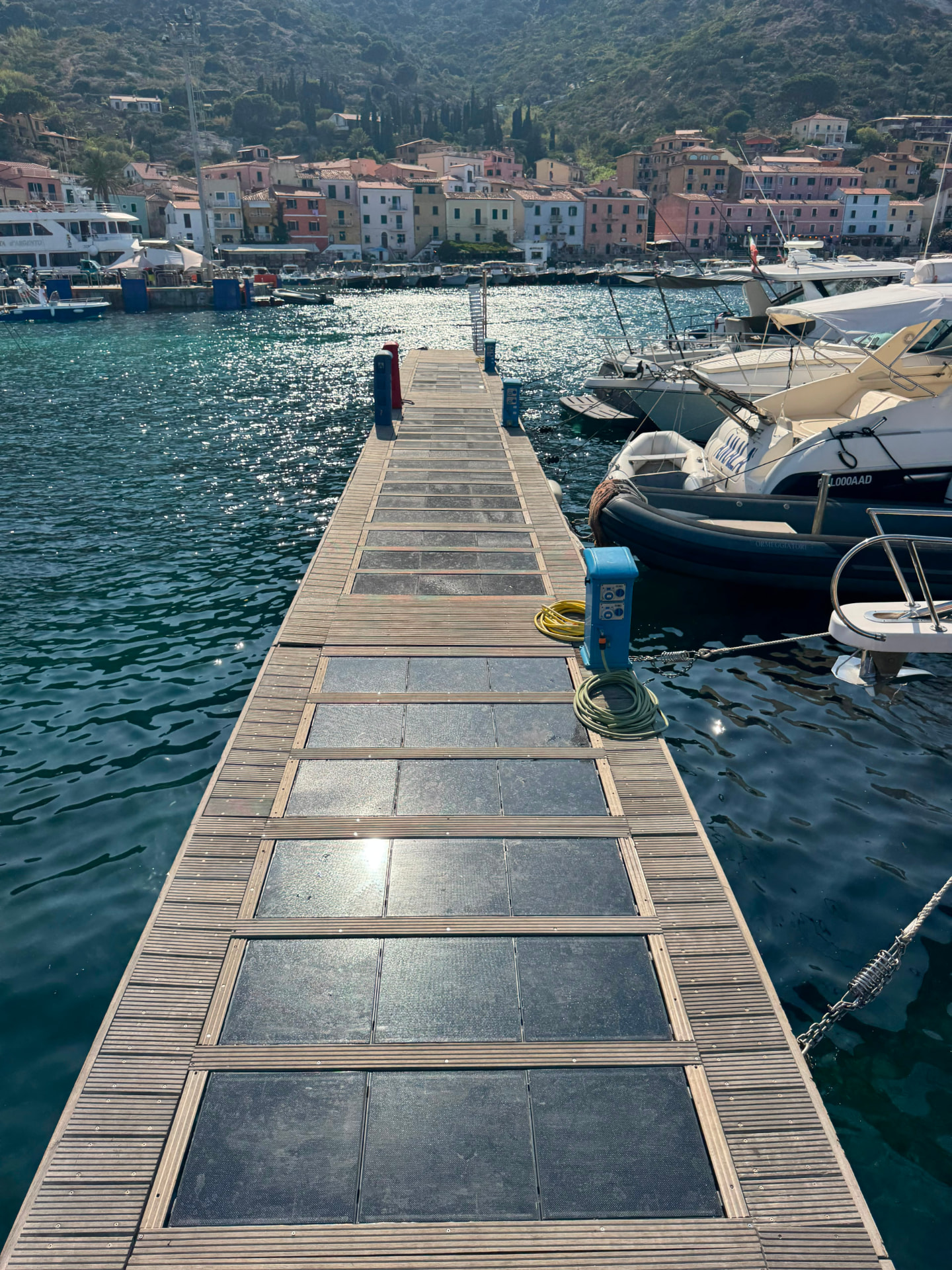 Il pontile fotovoltaico calpestabile visto verso il borgo del Giglio Porto